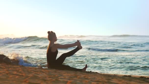 Прекрасная леди медитирует, занимаясь йогой на песчаном пляже — стоковое видео