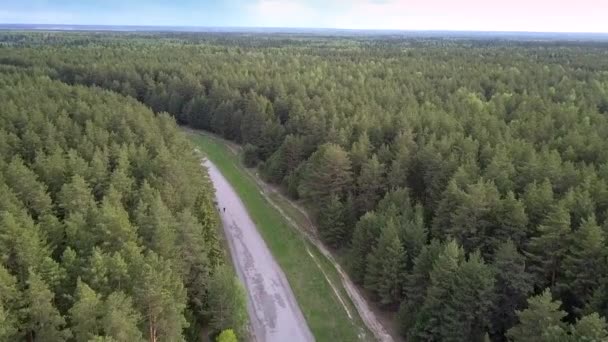 Biały samochód porusza się wzdłuż szarej drogi z ludźmi chodzenia — Wideo stockowe