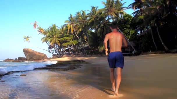 Deportista descalzo corre a lo largo de la costa oceánica pictórica — Vídeo de stock