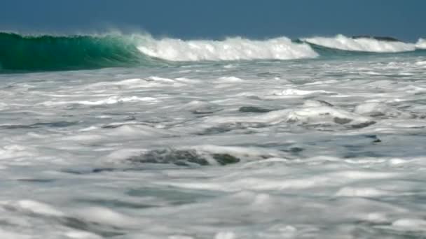 Enormes olas oceánicas fluyen bajo el cielo azul con espuma blanca — Vídeo de stock