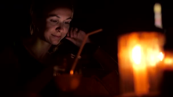 Kvinnan sitter på natten med telefon och tittar på kameran — Stockvideo