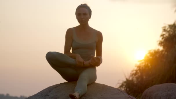 Практикующий йоги ставит ногу на бедро, делая асану замедленной движения — стоковое видео