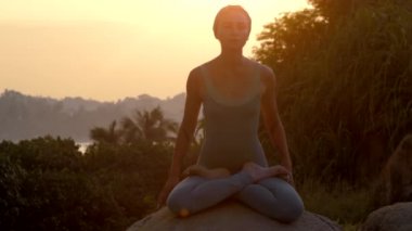 genç kadın büyük kaya yavaş hareket yoga asanas uygulamaları