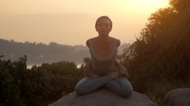 kız ileri bükme yavaş hareket ile baddha padmasana gösterir