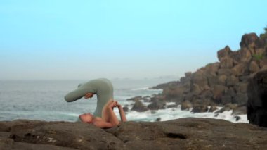 atletik kız kayalar yavaş hareket padma halasana içine alır