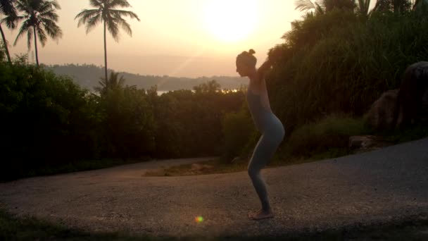 Chica muestra asanas de surya namaskara en parque cámara lenta — Vídeo de stock