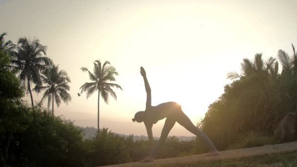 Girl gets out of revolved triangle asana on road slow motion — Stock Video