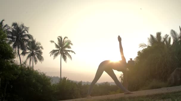 Femme pratique le yoga en triangle tournant pose au ralenti — Video