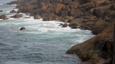 masmavi okyanus dalgaları kıyı yavaş hareket büyük kayalar üzerinde rulo