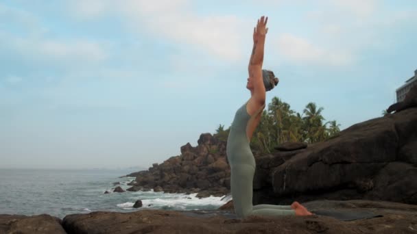 Flickan höjer händerna komma in ushtrasana på Sea slow motion — Stockvideo