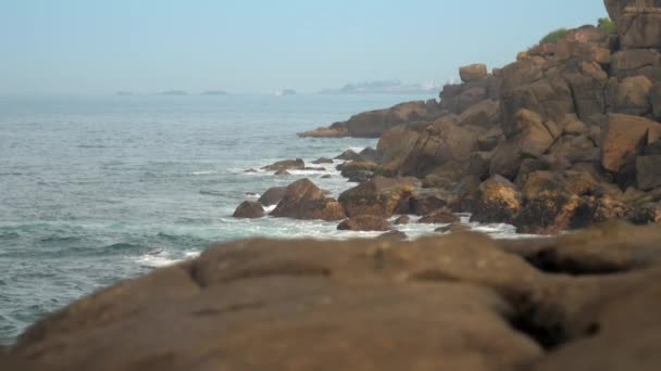 Sea coast with large stones against distant city slow motion — Stock Video