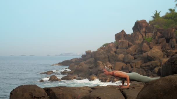 Mulher mostra urdhva mukha shvanasana na costa do mar câmera lenta — Vídeo de Stock