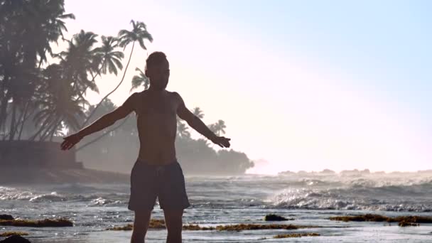 Athlète expérimenté étend les mains sur la plage de l'océan — Video