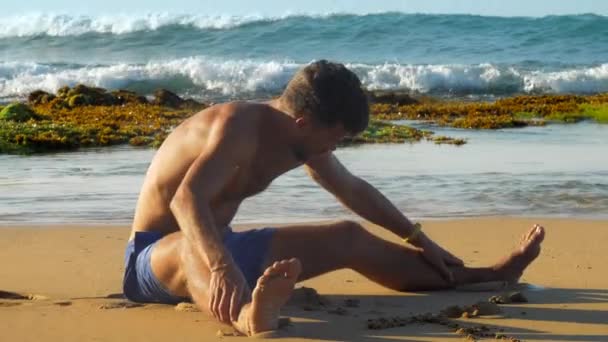 Knappe bebaarde man in blauwe shorts strekt zich traag — Stockvideo
