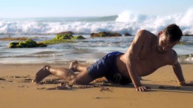 yakışıklı sakallı adam yoga pozisyonunda kumlu plajda duruyor