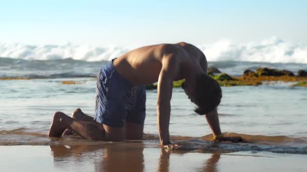 Homem descalço exercícios na água contra as ondas do oceano espumante — Vídeo de Stock