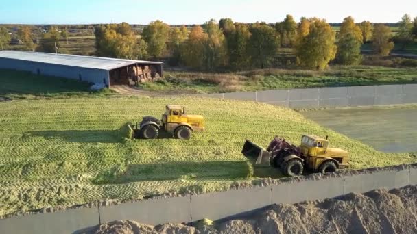 Luftudsigtsmaskiner arbejder i pit ramming silo på bedriften – Stock-video