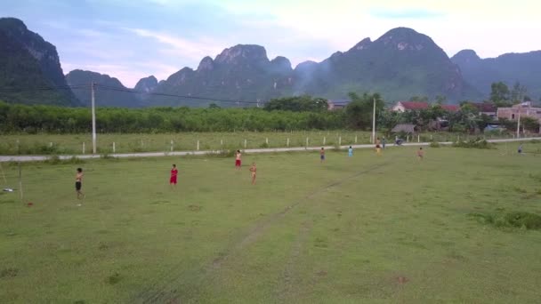 Fliegenkamera zeigt Kinder beim Fußballspielen im grünen Tal — Stockvideo