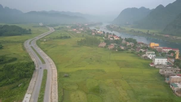 Hermosa vista de los campos verdes entre el pueblo y la carretera — Vídeos de Stock