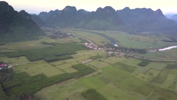 Luchtbeweging boven groene velden en kalm klein dorp — Stockvideo