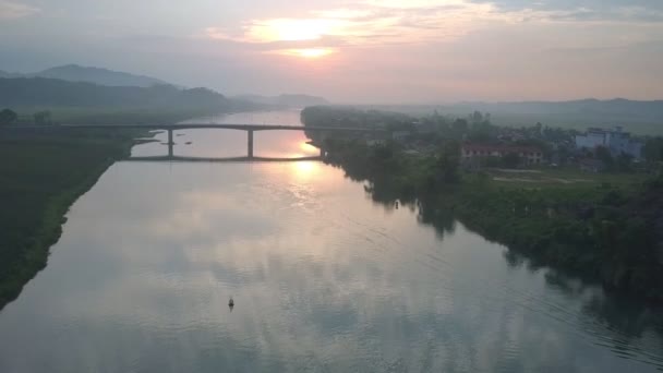 Tropische rivier onder smalle brug tegen zomer zonsondergang — Stockvideo