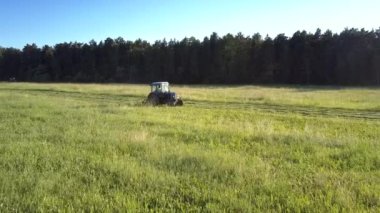 çiftçi sahada saman için çim biçme traktör çalışır