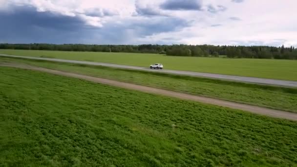 Witte moderne auto rijdt langs Gray asfalt weg — Stockvideo