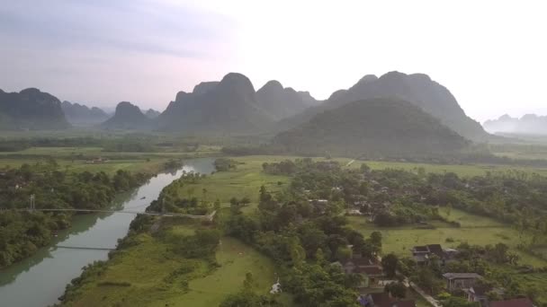 Río azul con puente blanco entre la pequeña ciudad y los campos — Vídeos de Stock