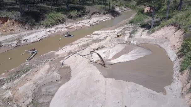 Lange dunne pijp extracten nat zand van smalle modderige rivier — Stockvideo