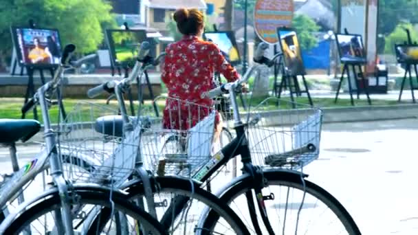 Жінка в червоній блузку на відкритому повітрі художня галерея і велосипеди — стокове відео