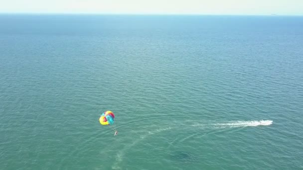 Fallschirm fliegt hinter weißem Motorboot über Meer — Stockvideo