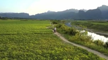 insanlar yol geçmiş alan ve nehir ani boyunca scooter binmek