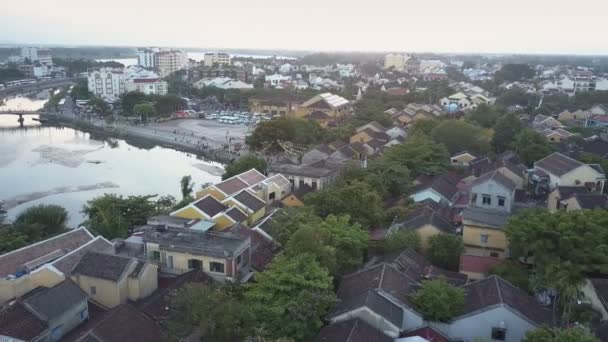 Vista superior pequeños edificios entre árboles verdes cerca del río — Vídeos de Stock