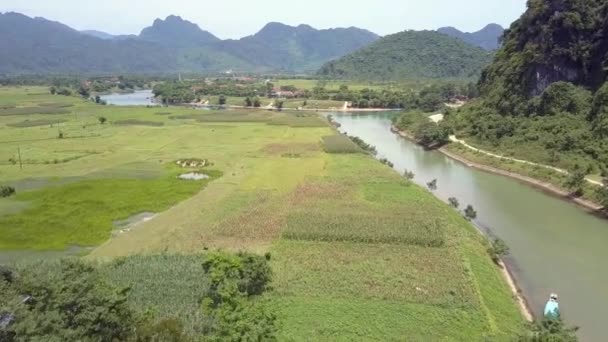 Воздушное движение над полями спокойного берега реки против холмов — стоковое видео