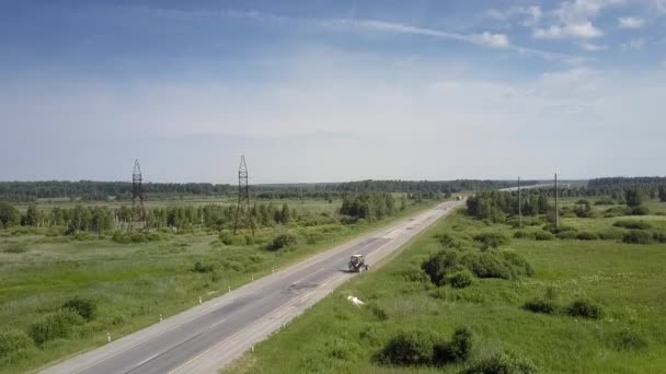 Antennenschlepper senkt Messer und mäht Gras am Straßenrand — Stockvideo