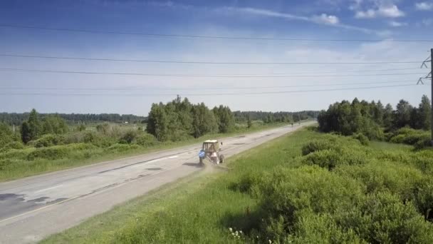 Ciągniki trawy wzdłuż Wayside pod linią wysokiego napięcia — Wideo stockowe