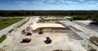 kazıcı ve damperli işçilerle açık kum çukuru üst görünümünde