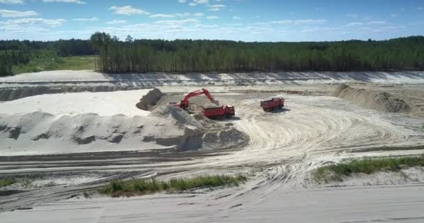 Cámara se eleva por encima de pozo de arena con excavadora y camiones volquete — Vídeo de stock