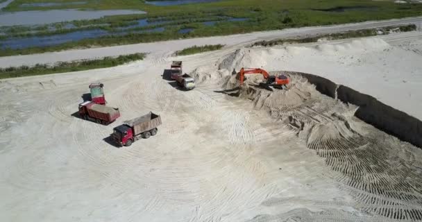 Koparka wykopuje piasek do napełniania ciężarówek końcówki w kamieniołomie widok z góry — Wideo stockowe
