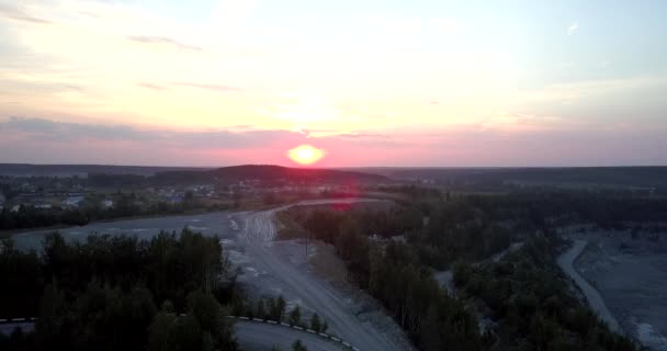Le soleil orange se couche sur une petite ville dans un secteur minier obsolète — Video