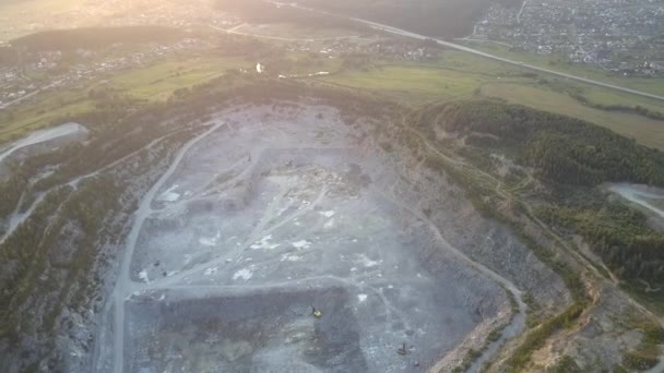 carrière énorme d'extraction de gravier avec des machines spéciales au coucher du soleil 