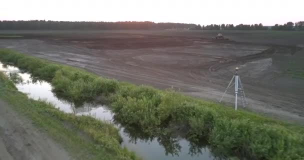 Letecký pohyb přes pole s teodolitem a tažným traktorem — Stock video