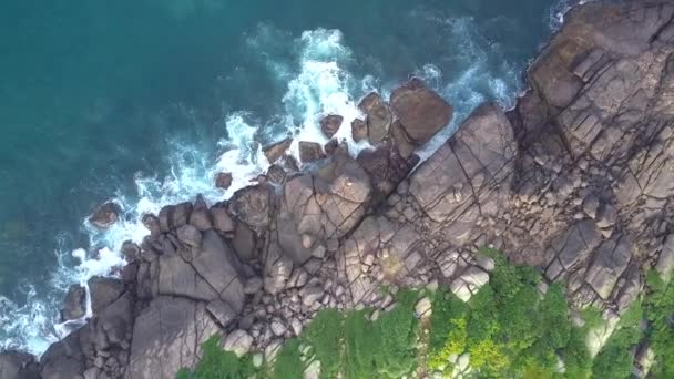 Узбережжя тропічного океану з великими каменями і гнучкою жінкою — стокове відео