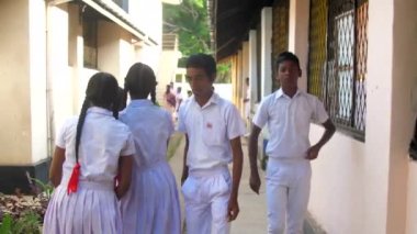 Sinhalese erkek ve kız binalar arasında yürümek