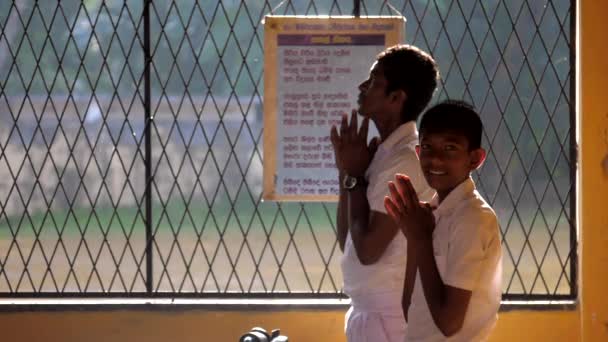 Sinhalese schoolboys in white uniforms pray slow motion — Stock Video