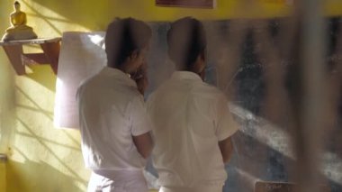 Sinhalese okul çocukları yavaş yavaş siyah masada dua