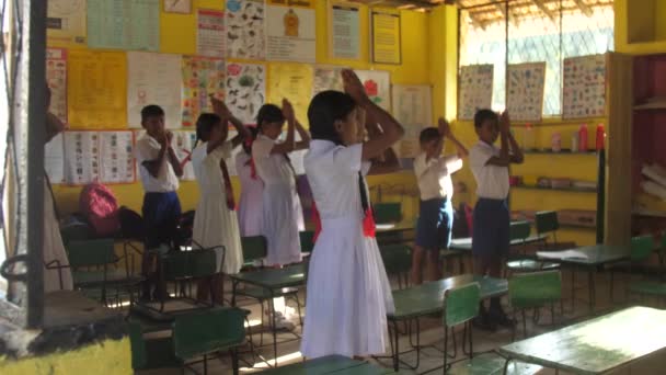 Les écoliers prient debout en classe avant la leçon — Video