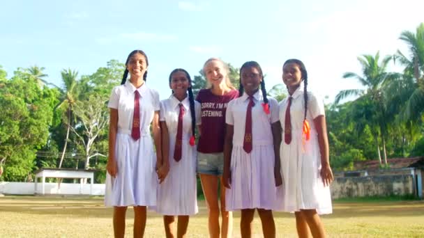 Freiwilliger Arbeiter umgeben von singhalesischen Schulmädchen — Stockvideo