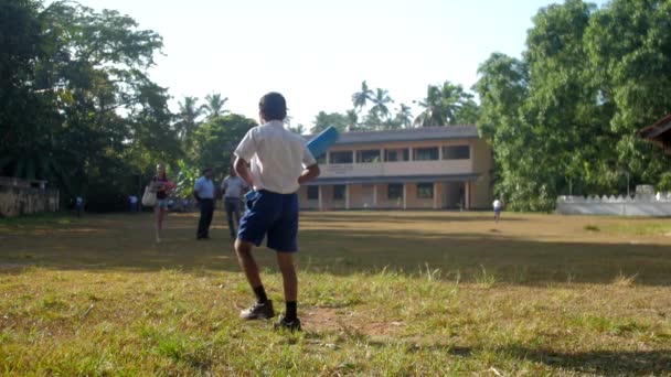 Genç Sinhalese öğrenci yeşil oyun boyunca yürüyor — Stok video