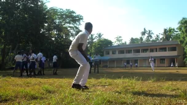 Garçon cinghalais en uniforme d'école blanche chauve-souris balle — Video